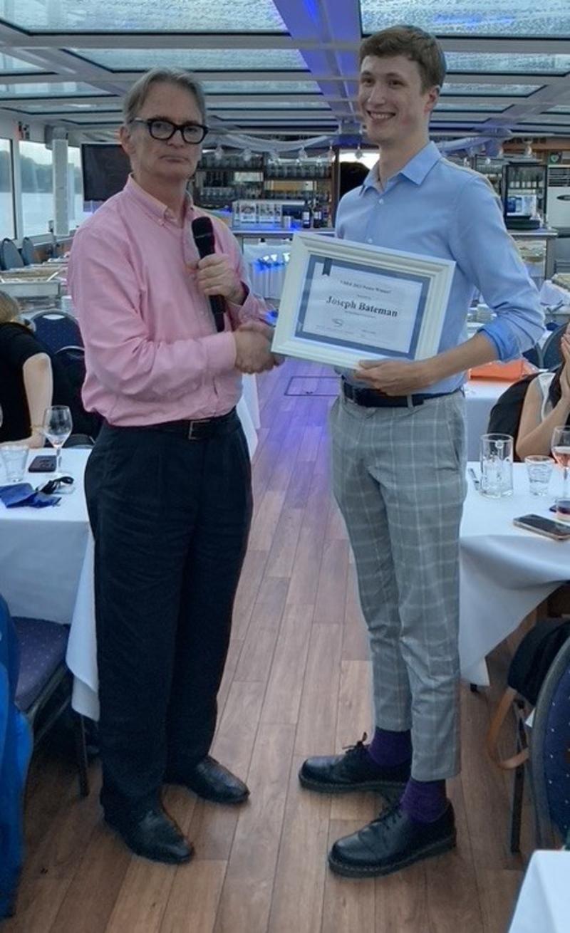 Prof. Roger Jones of Manchester University presents Joe Bateman with the poster prize at the VHEE'2023 conference dinner