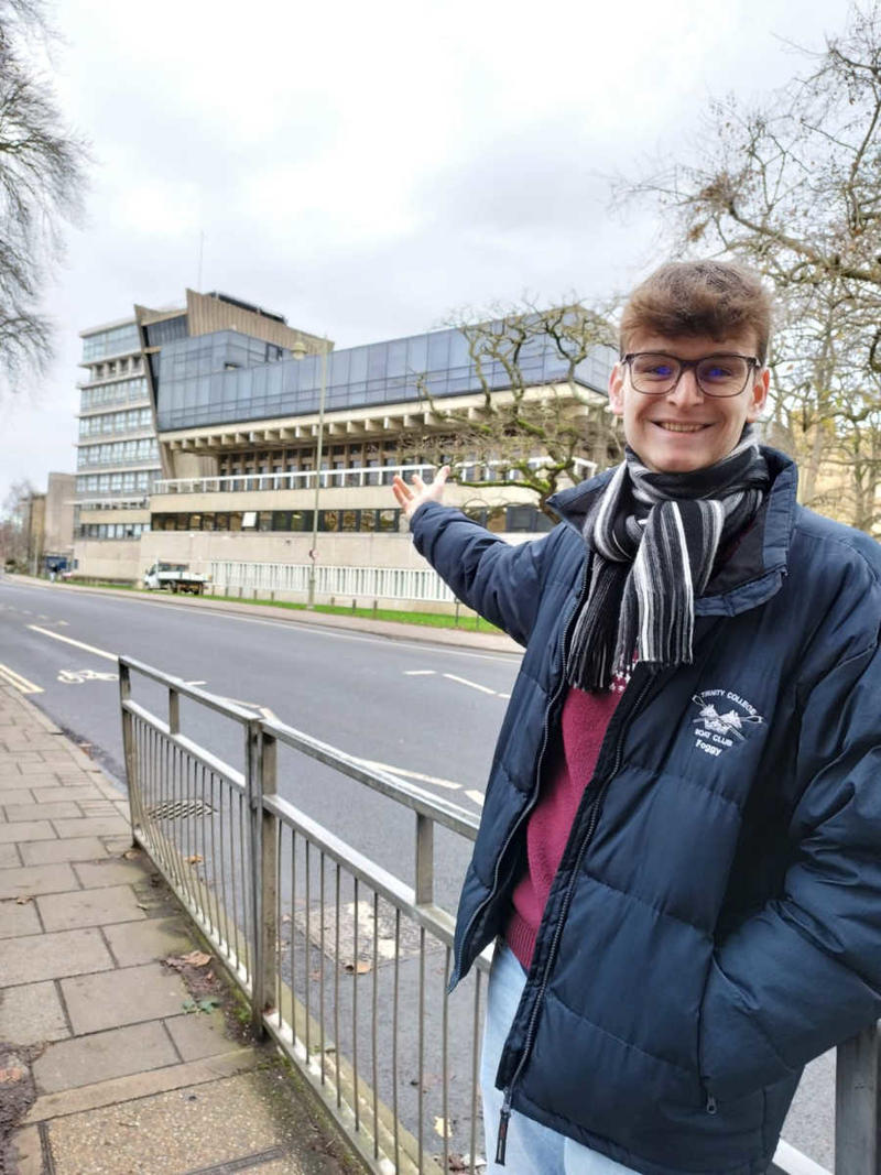 Thomas Fogg proudly pointing to the Denys Wilkinson Building where he completed his award-winning MPhys project on the innovative GaToroid particle therapy system.